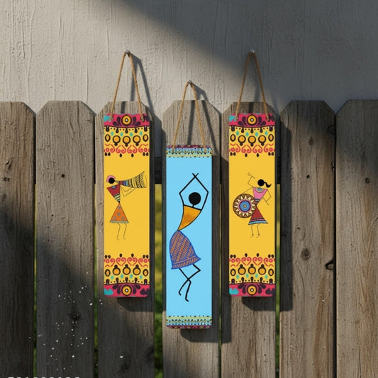 Three colorful wall hangings with abstract designs on a wooden fence.