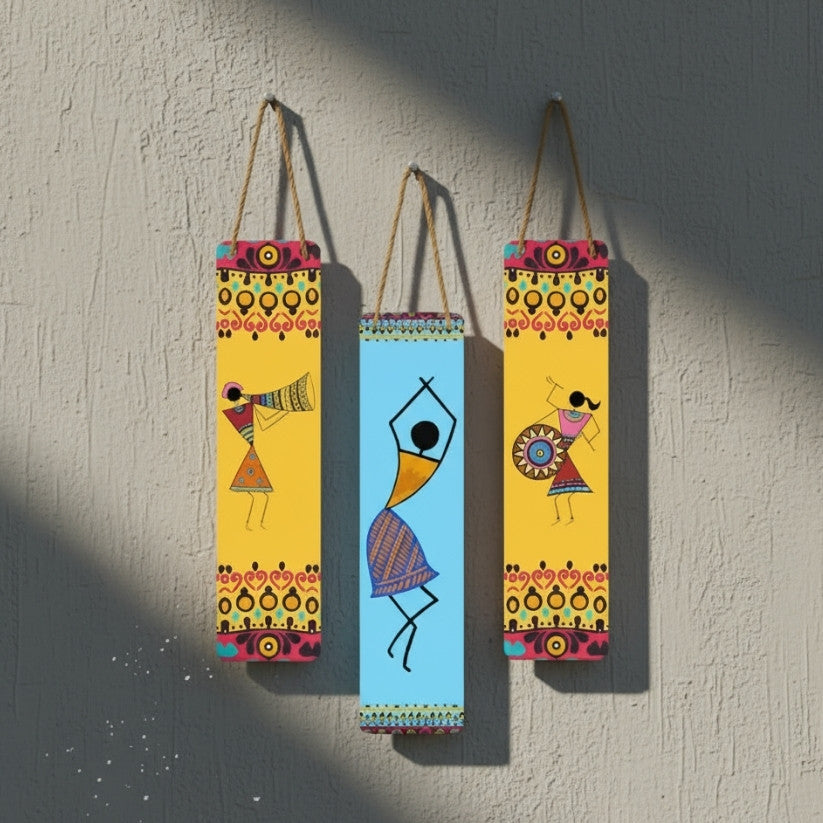 Three colorful wall hangings with abstract designs of people on a textured wall.