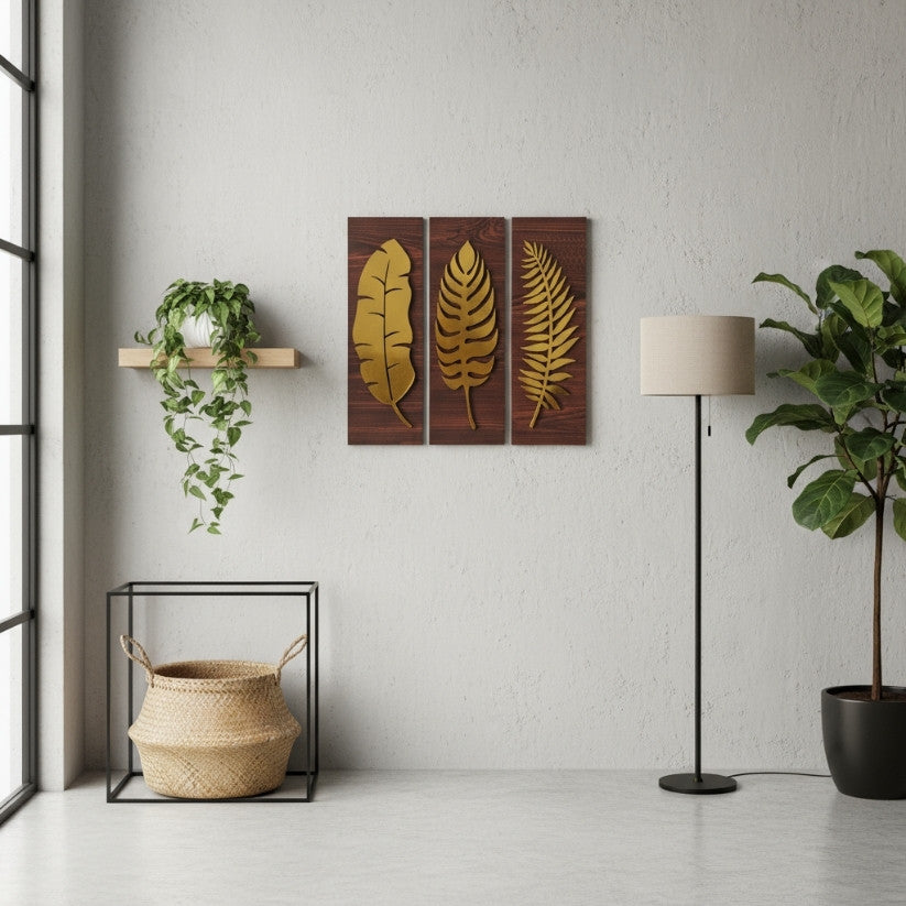 Decorative wall art with leaf designs in a room with plants and a lamp.