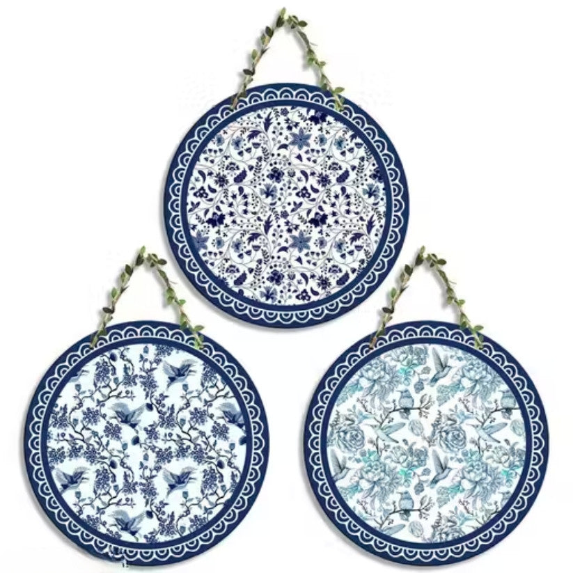 Set of three decorative plates with blue and white floral patterns on a white background